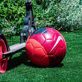 Fußball liegt auf gepflegtem Rasen, der durch gleichmäßige Bewässerung dauerhaft belastbar bleibt