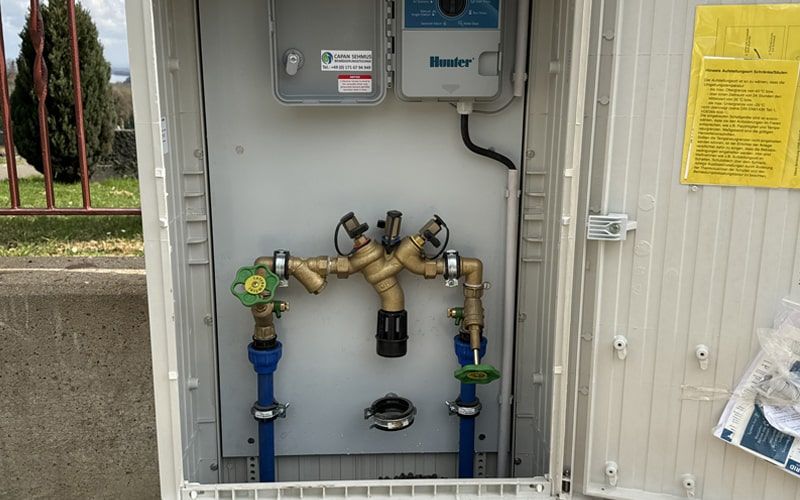 Automatische Rasenbewässerung mit Sprühregnern auf dem Friedhofvorplatz in Weiler bei Bingen