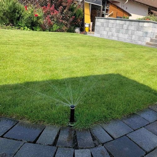bewaesserung-privatgarten-rasenkante Präzise installierter Versenkregner bei der Bewässerung einer Rasenkante im Privatgarten