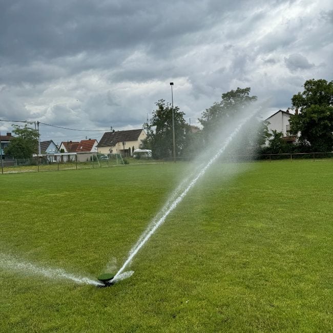 Eine Sportplatzberegnung die den Fussballplatz in Frankfurt beregnet