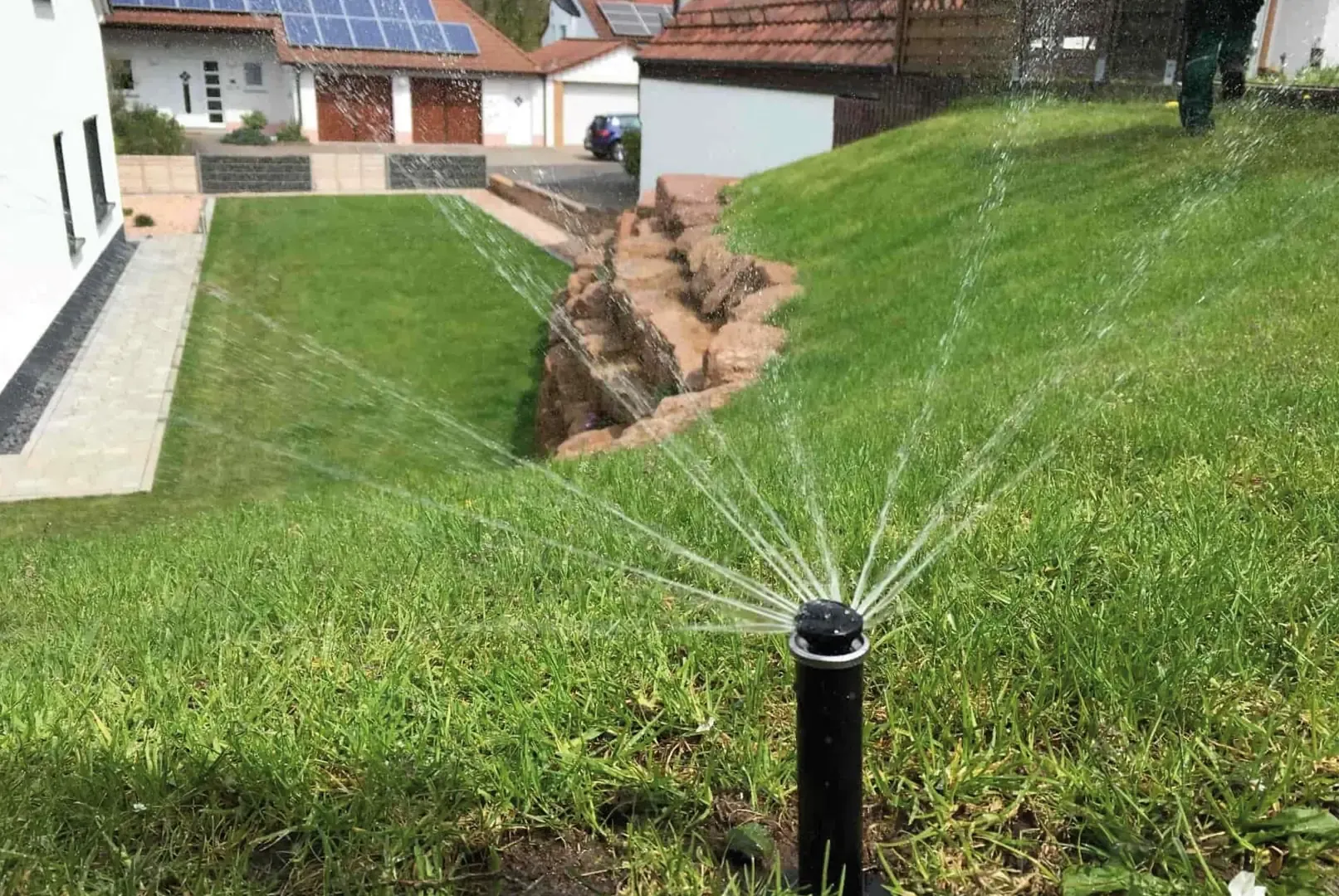 Automatische Bewässerung einer anspruchsvollen Hanglage mit Natursteinmauern und präziser Regnereinstellung