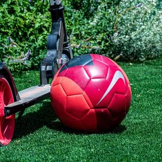 Fußball liegt auf gepflegtem Rasen, der durch gleichmäßige Bewässerung dauerhaft belastbar bleibt