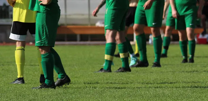 Fußballspieler auf Rasen während des Spiels als Motiv für Sportplatzberegnung und gleichmäßige Bewässerung der Spielfläche